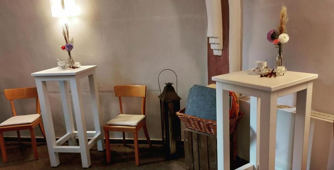 WWeiße Stehtische aus Holz im Gewölbe der Kirche